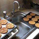 Being There Freshly baked ginger cookies on trays, cooling by my sink.