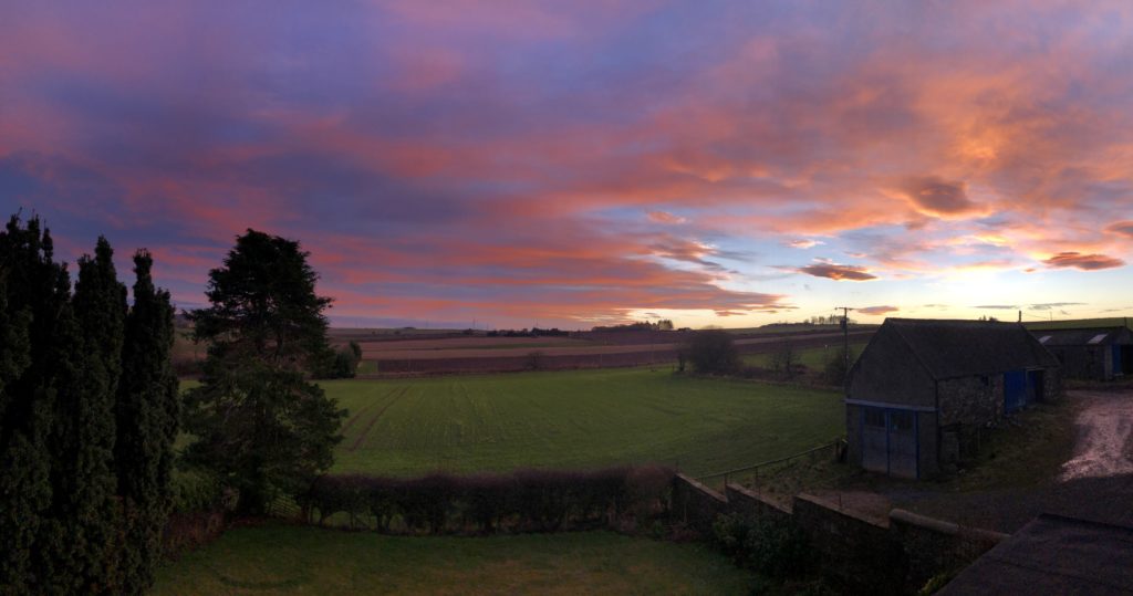 Extremely colourful orange and purple sky over Aberdeenshire farmland.