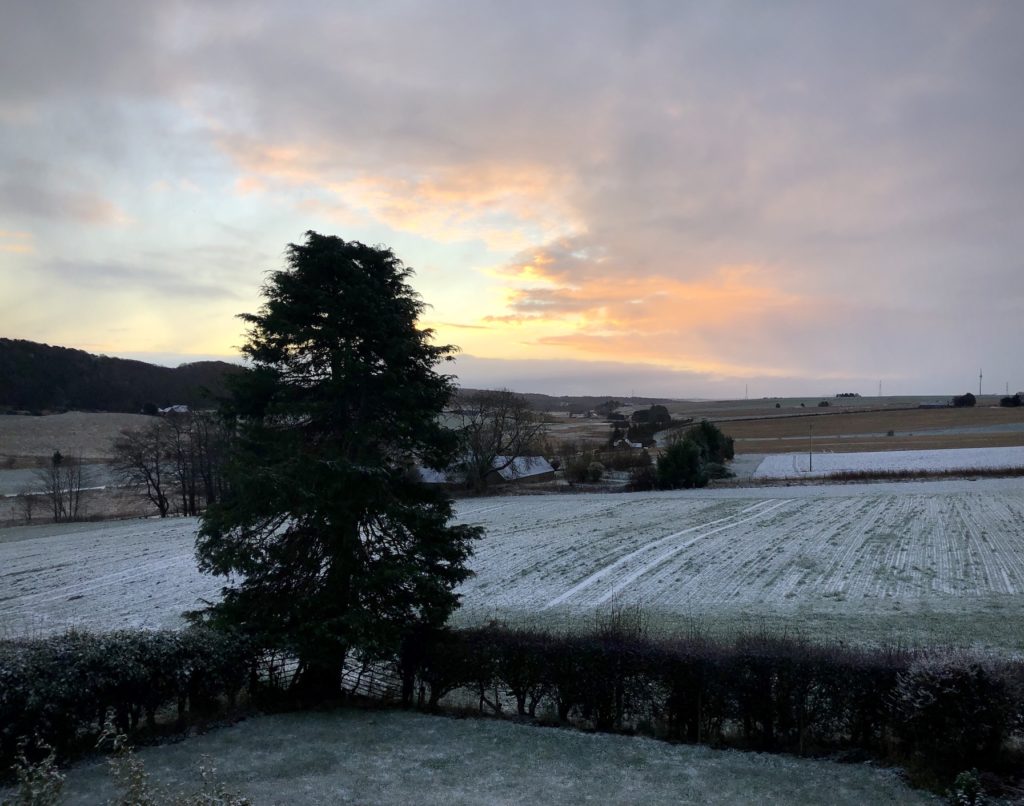 Photo of the farmland by my house, featuring a sunrise and a dusting of snow on the fields.