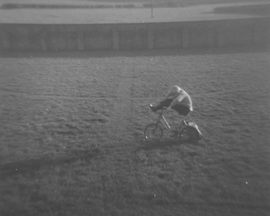 bitton trike Me, sitting on a tricycle on the school playing field, my feet up on the handlebars